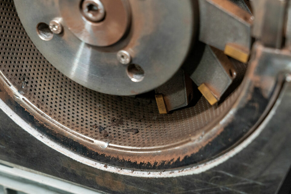 Hammer cutting mill - close-up of the perforated basket and the cutting rotor after crushing charcoal fibers